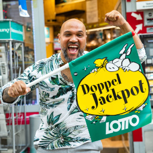 Trafikant mit Lotto-Fahne in Siegerpose